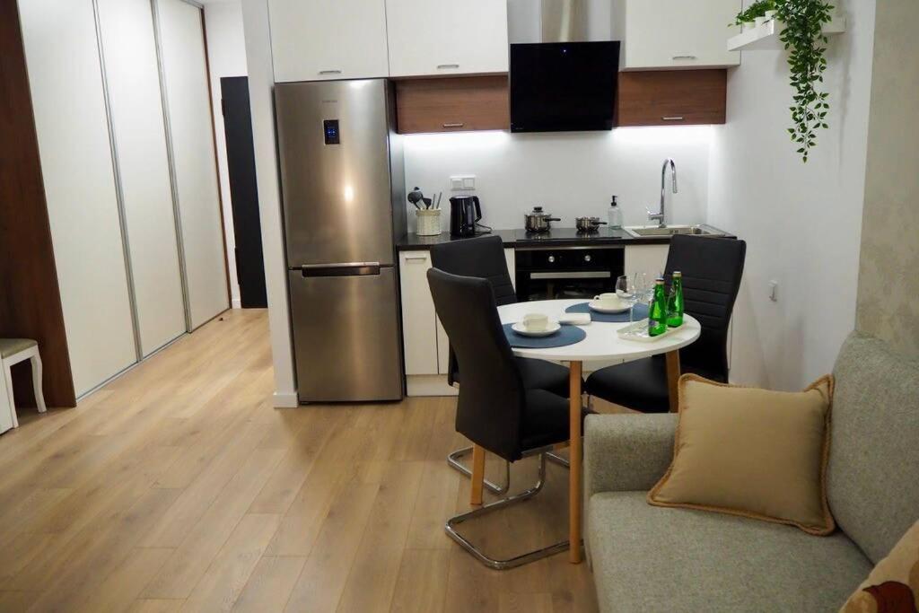 a kitchen with a table and a stainless steel refrigerator at Studio Nr 4 close to Medicover and Paley Institute in Warsaw