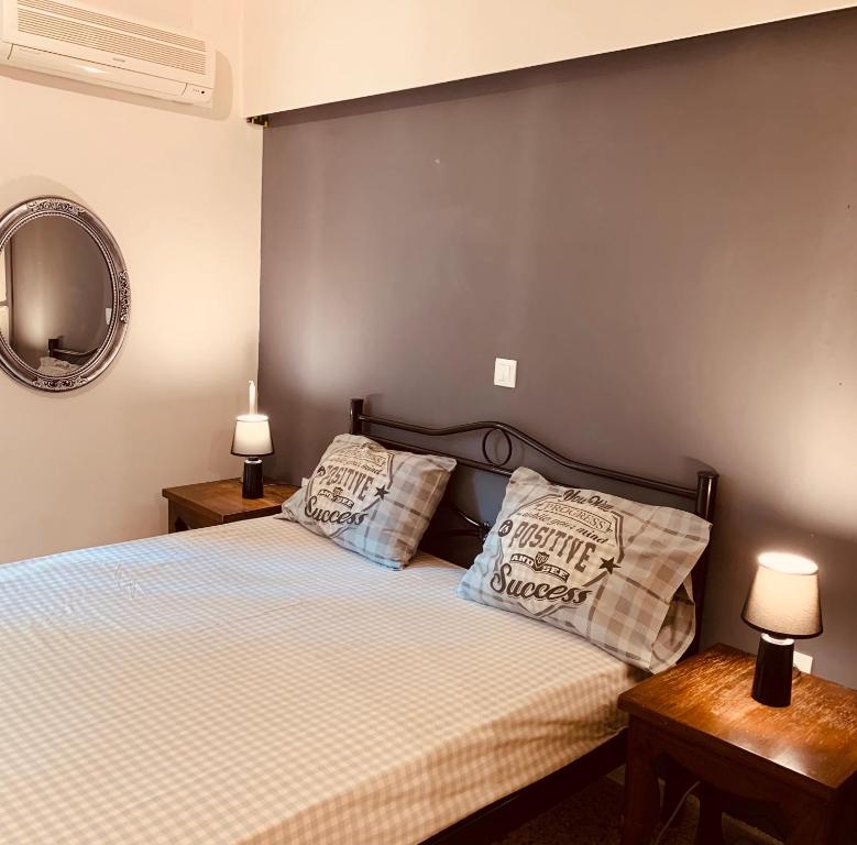 ein Schlafzimmer mit einem Bett mit zwei Kissen darauf in der Unterkunft Modern Apartment in The Heart of Athens Near Acropolis in Athen