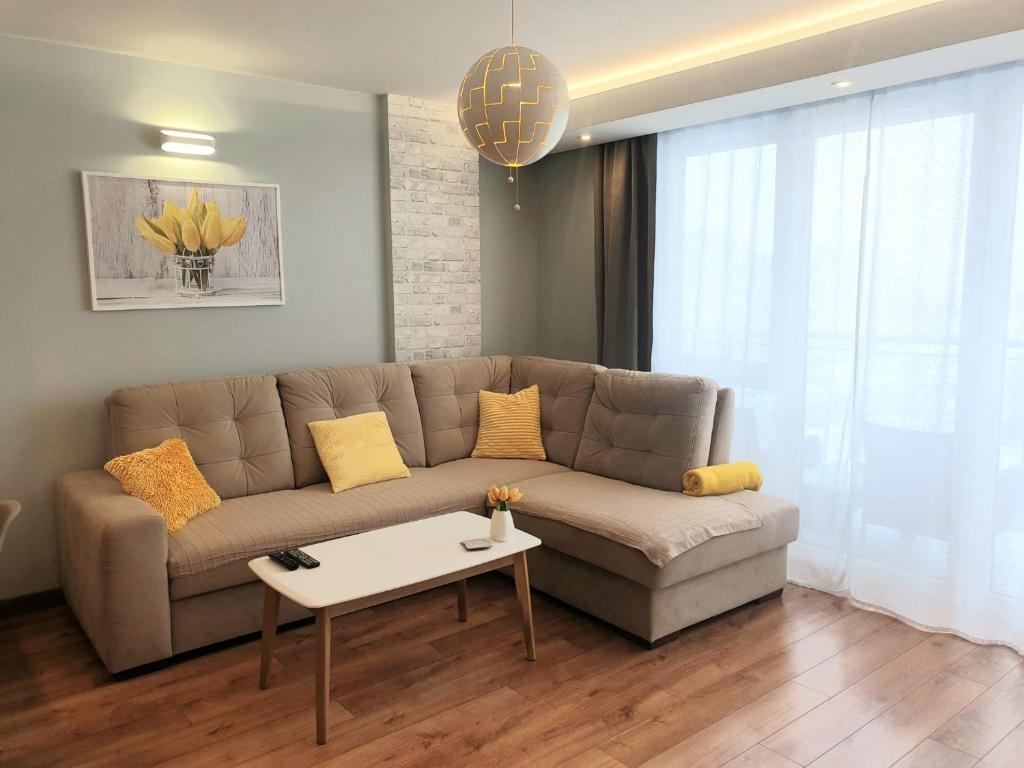 salon z kanapą i stołem w obiekcie Apartament Jurajska Plaza, prywatne miejsce parkingowe , Targi w Kielcach
