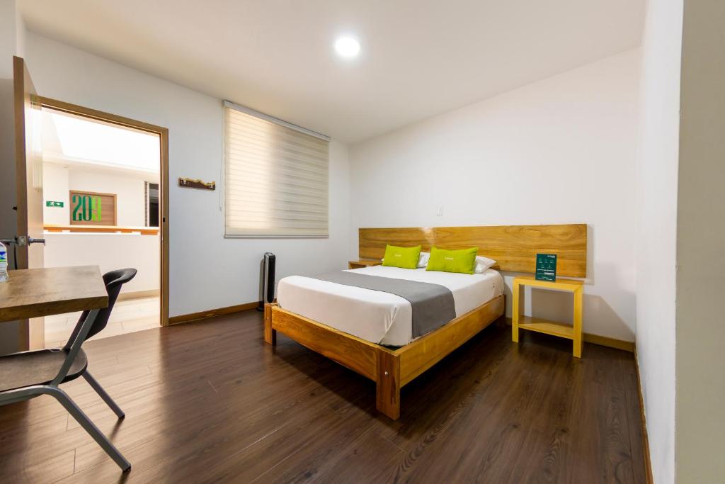 a bedroom with a bed and a table and a desk at Hotel Ayenda Marckia 1901 in Armenia