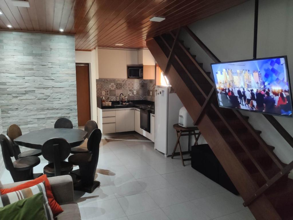 Il comprend un salon doté d'une table et d'une télévision à écran plat. dans l'établissement Winterville Gravatá Flat 1011, à Gravatá