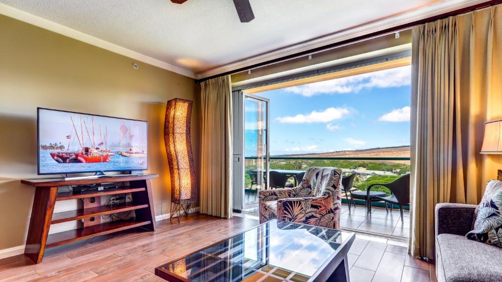 a living room with a television and a glass table at Honua Kai - Konea 1024 in Lahaina