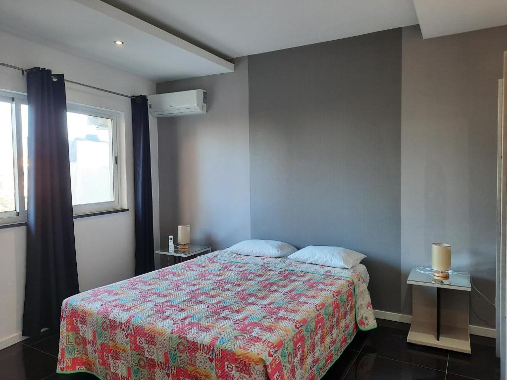 a bedroom with a bed with a colorful blanket at Mar House Apartments in Praia