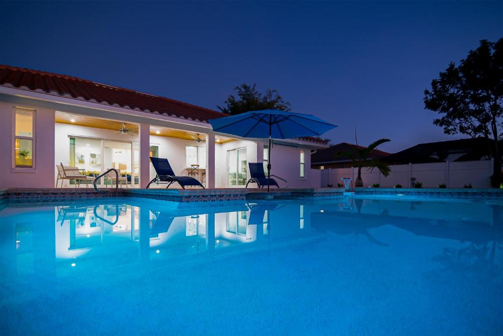 a swimming pool with two chairs and an umbrella at Bonita Lake House in Bonita Springs