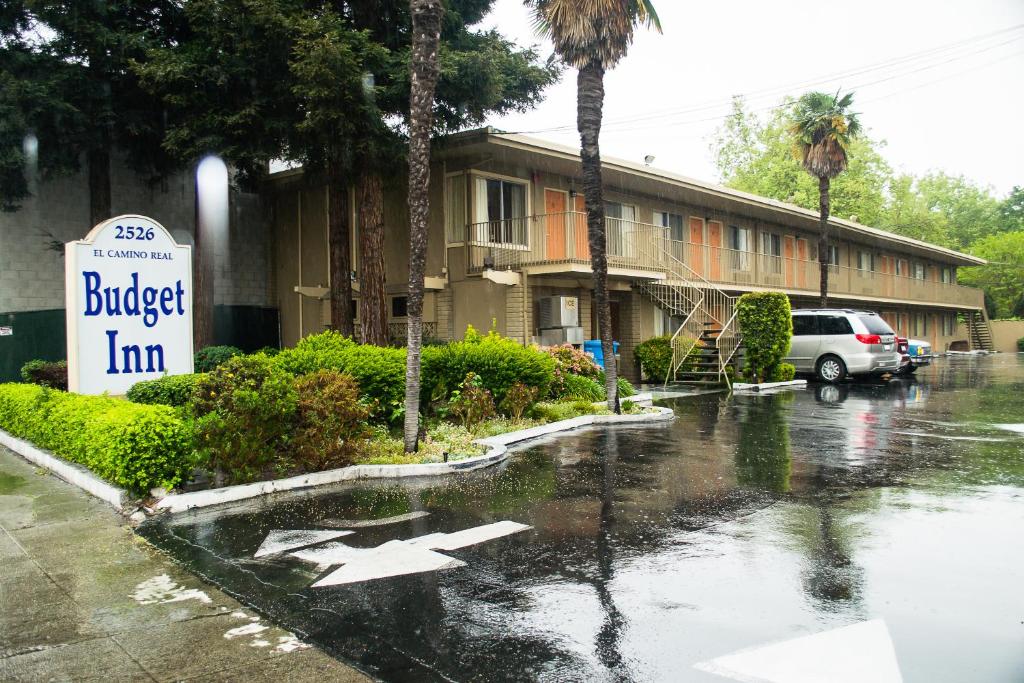 a flooded street with a building and a sign at Budget Inn Redwood City in Redwood City