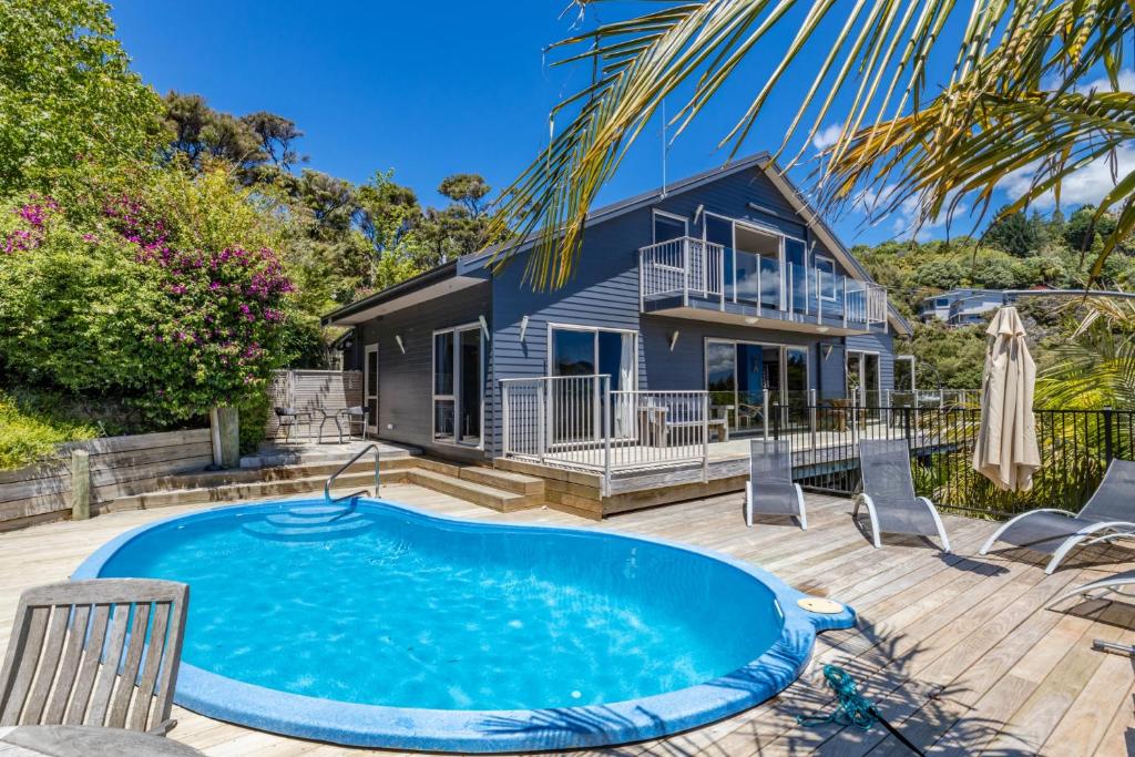 a home with a swimming pool and a house at Harbour View in Whangaroa
