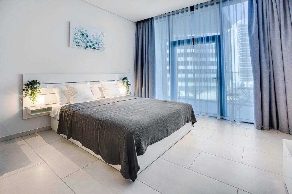 a bedroom with a bed and a large window at Beautiful apartment with Burj Khalifa view in Dubai