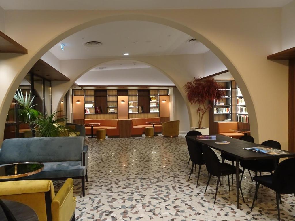 a lobby with an archway and tables and chairs at Aquabella Hôtel & Spa in Aix-en-Provence