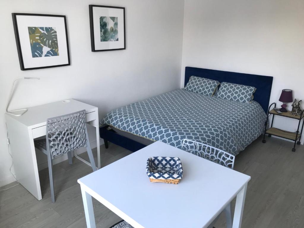 une petite chambre avec un lit et une table dans l'établissement Cosylocation Le Bois Perrin, à Rennes