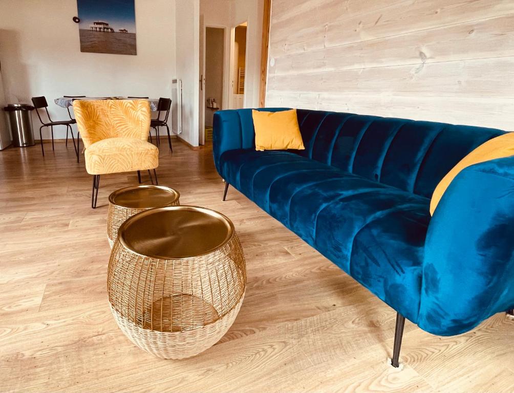 a living room with a blue couch and chairs at Maison Bois du Bassin in Andernos-les-Bains