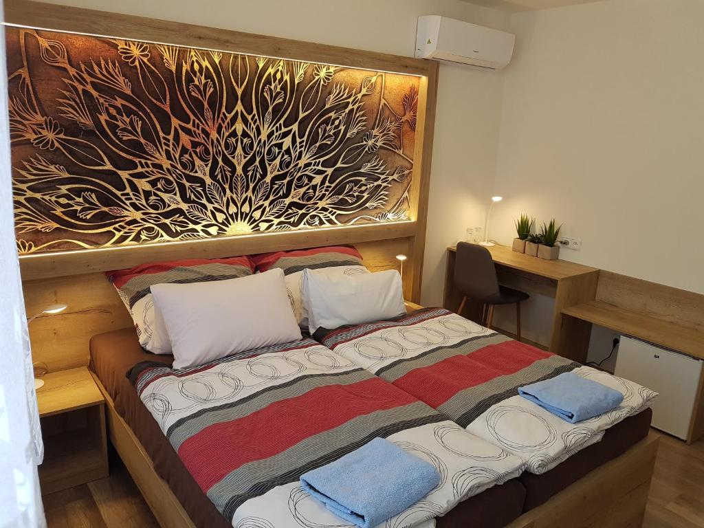 Hotel Gól Prostějov في بروستيوف: غرفة نوم بسرير مع لوحة على الحائط