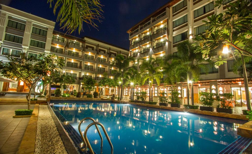 a hotel with a swimming pool at night at Royal Empire Hotel in Siem Reap