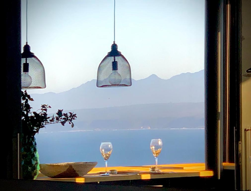 uma janela com dois copos de vinho numa mesa em Best View @ No 2 em Plettenberg Bay