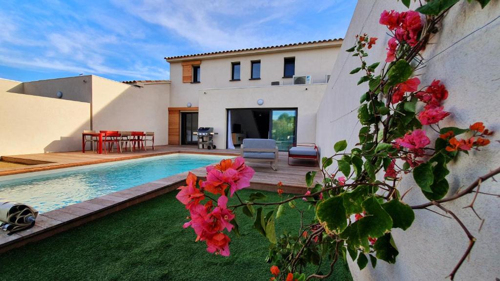 a house with a swimming pool and flowers at Villa Nananthée T5 de luxe,4-8 pers, piscine privée chauffée in Lecci