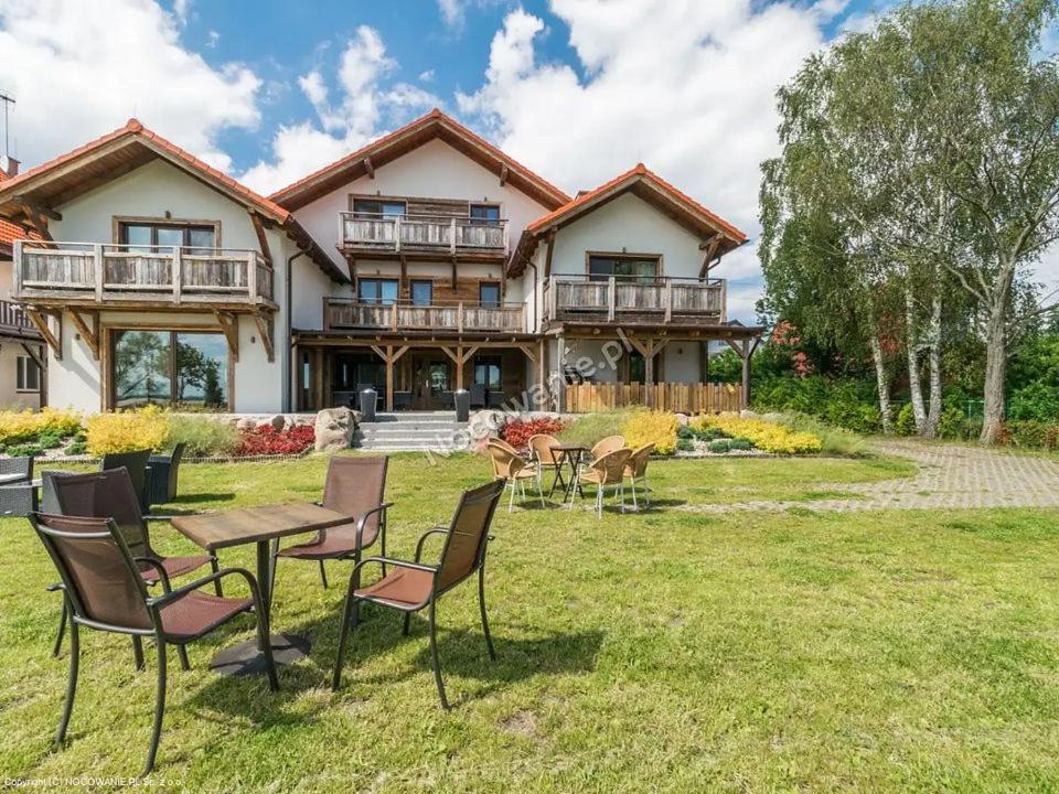 a house with a table and chairs in the yard at Aparthotel Baltic Willa in Krynica Morska