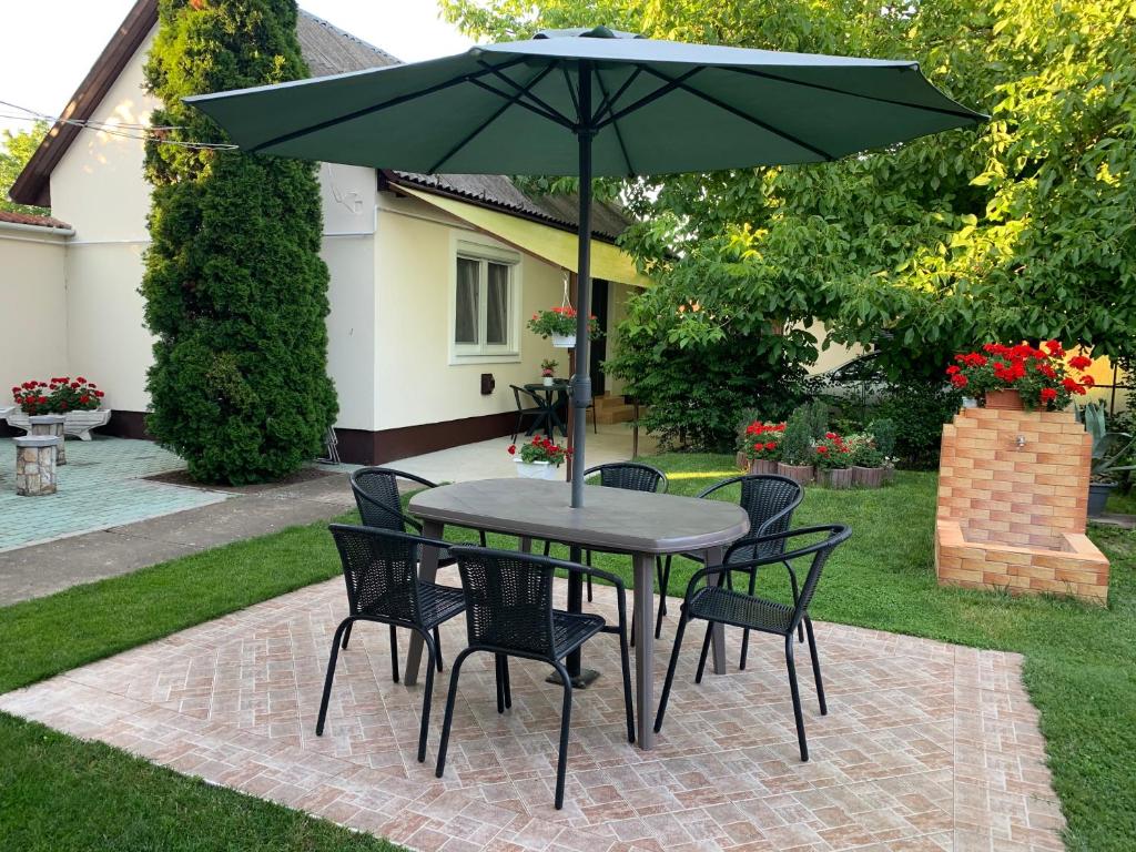 stół i krzesła z parasolem na dziedzińcu w obiekcie Katarina apartman w Hajduszoboszlo