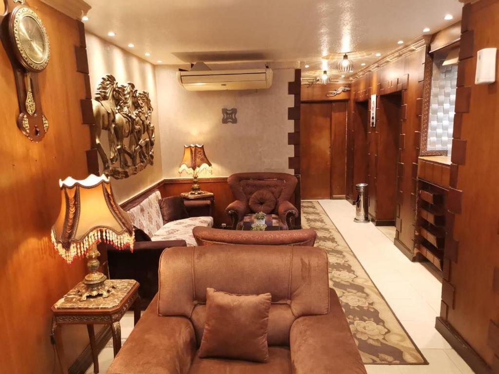 uma sala de estar com um sofá, cadeiras e uma mesa em City Center Hotel Beni Suef em Banī ‘Aţīyah