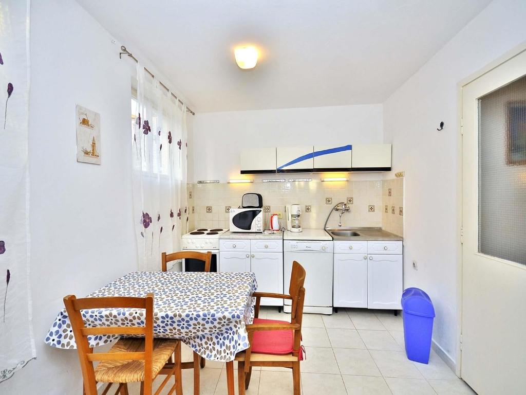 kuchnia ze stołem i krzesłami oraz stołem i stołem w obiekcie Apartments Miro 636 w Rovinj