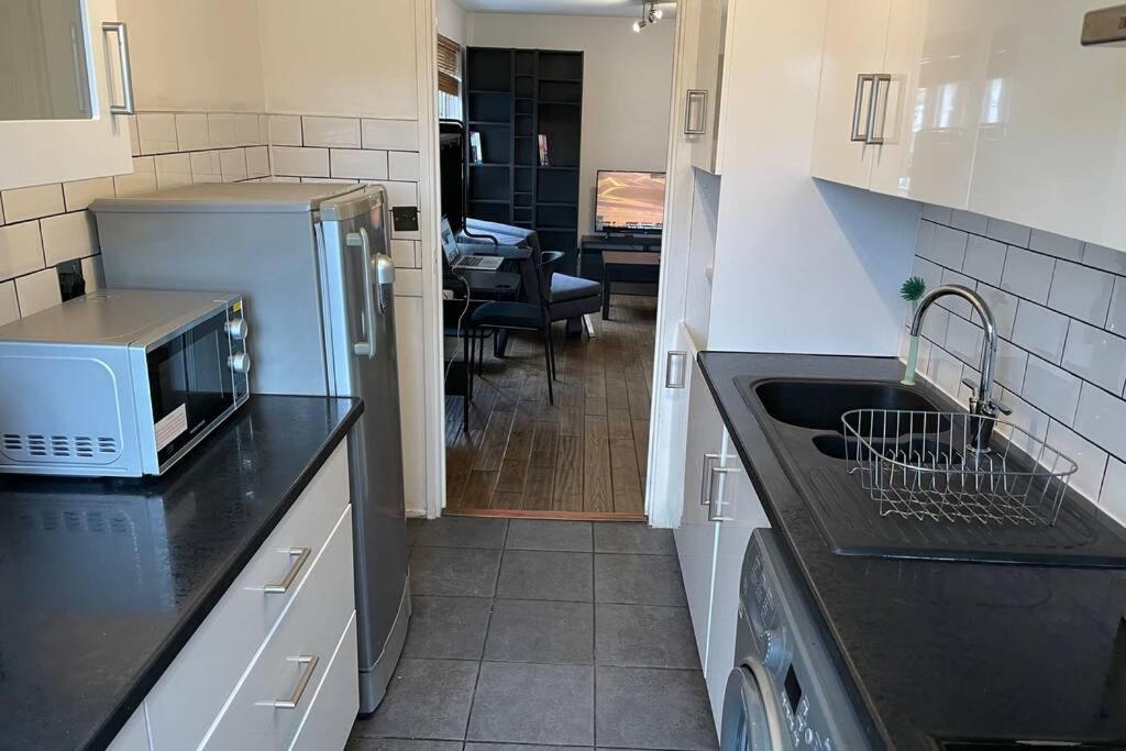 a kitchen with a sink and a dishwasher at Beautiful apartment right off of Broadway Market in London