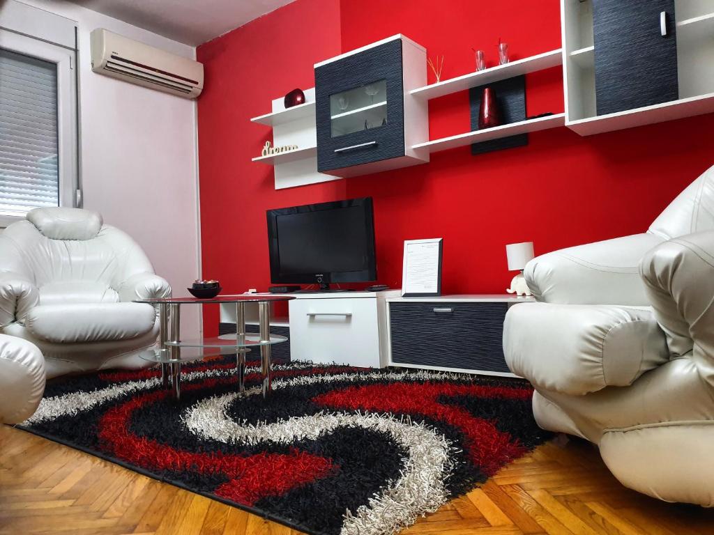 un soggiorno con 2 sedie e una parete rossa di Apartment Centar Deluxe a Smederevo