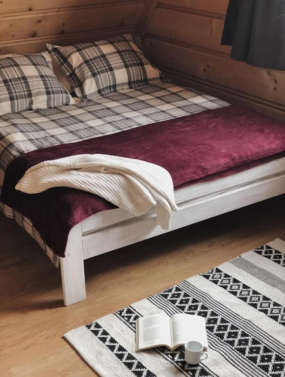 a bed with a blanket and books on the floor at Pokoje u Małgorzatki in Murzasichle