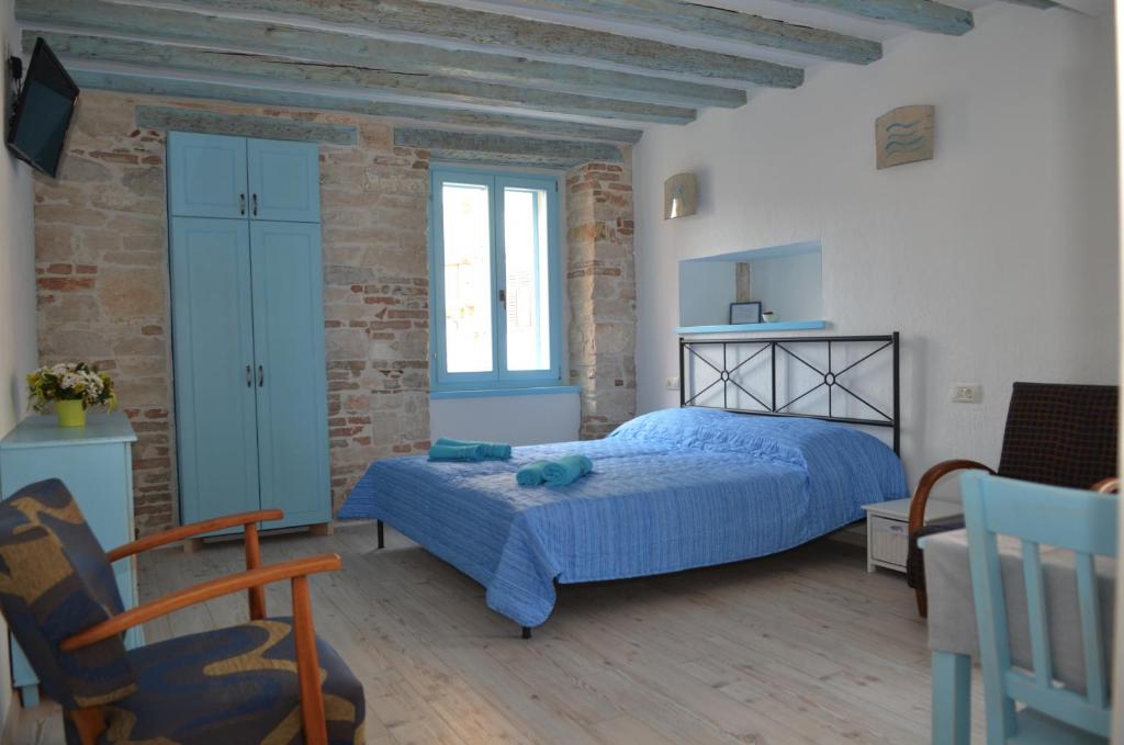 a bedroom with a bed and a brick wall at Studios Barbaro in Rovinj