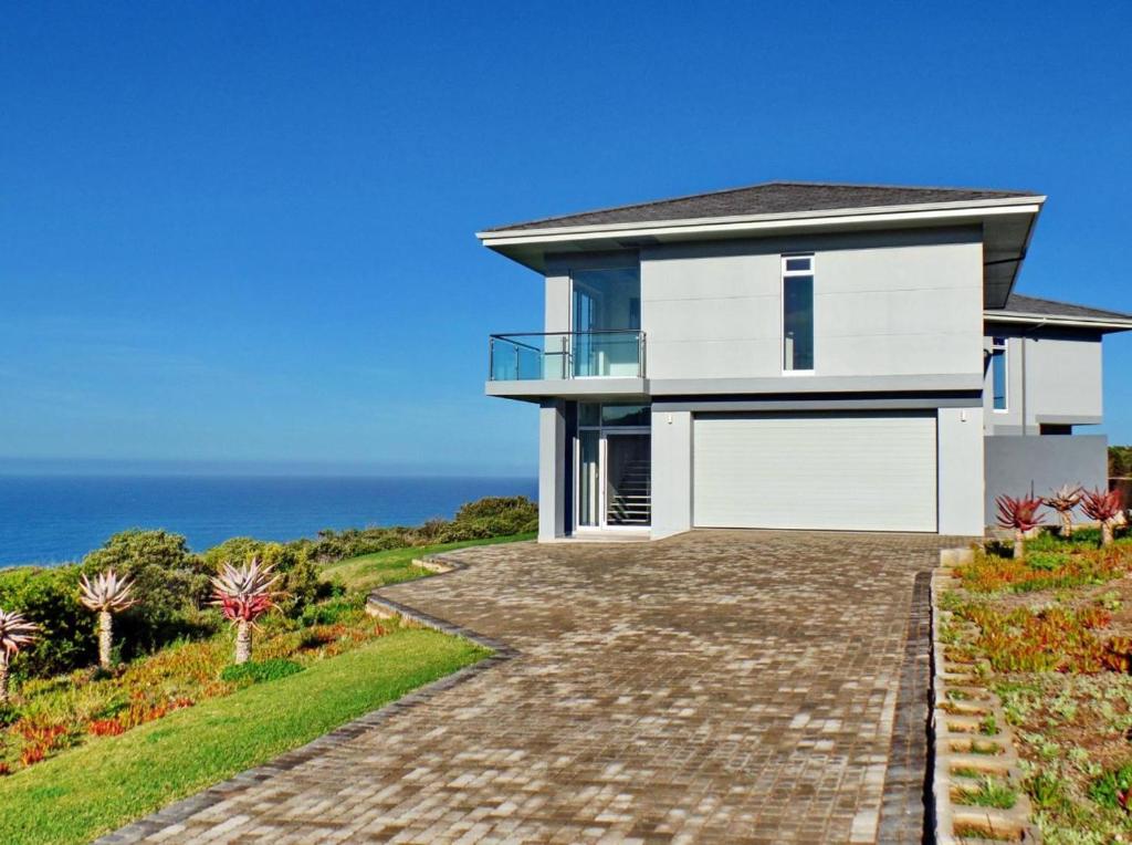 une maison avec l'océan en arrière-plan dans l'établissement The BlueHouse, à Mossel Bay