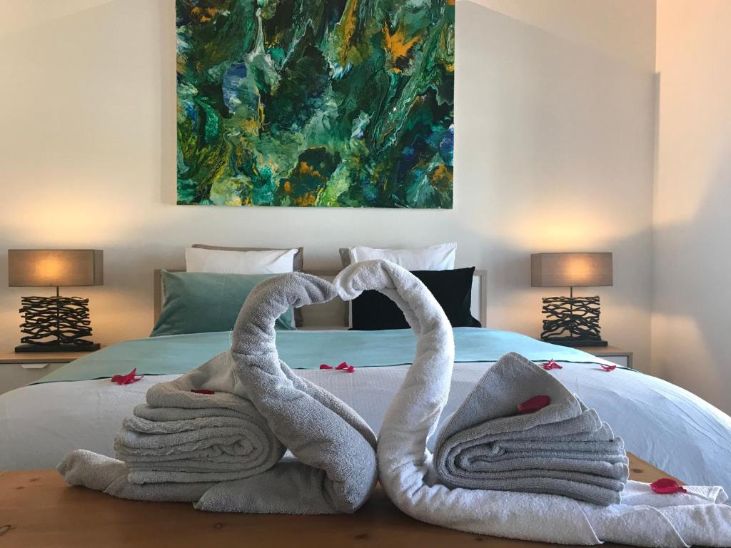 two towel swans sitting on top of a bed at Maison SANS SOUCI in Lajoux