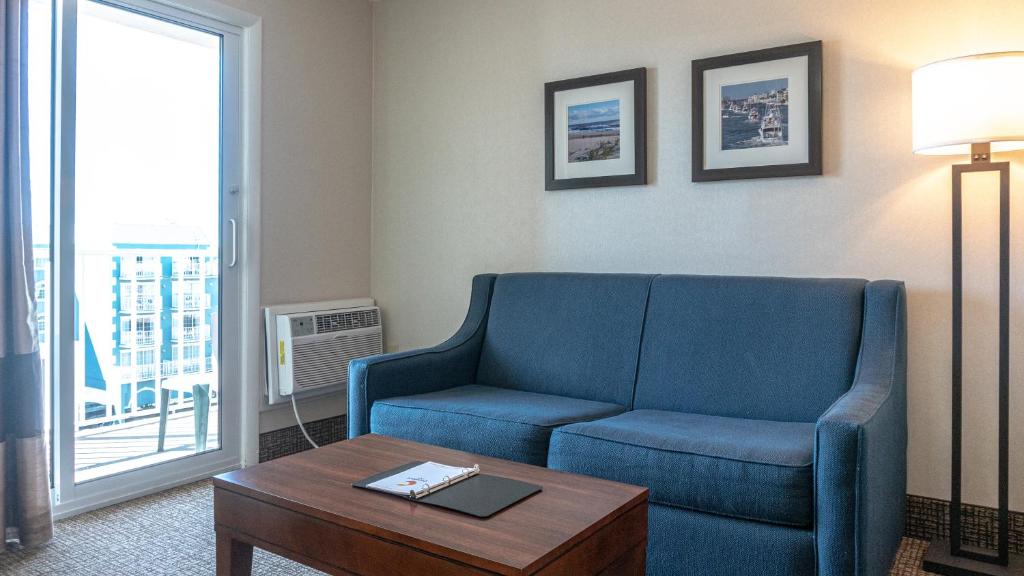 a living room with a blue couch and a table at Comfort Inn Ocean City Boardwalk in Ocean City