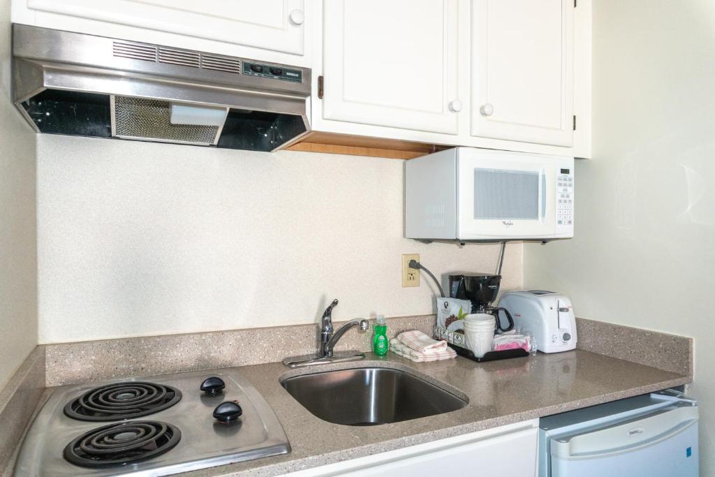 a kitchen with a sink and a stove top oven at Comfort Inn Ocean City Boardwalk in Ocean City
