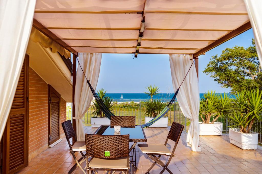 un patio con tavolo, sedie e vista sull'oceano di MARCHE FULL EXPERIENCE-Apartments a Porto SantʼElpidio