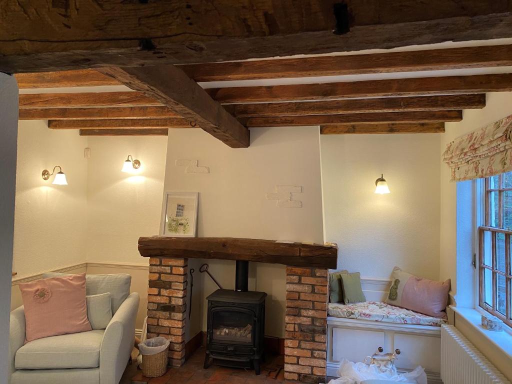 a living room with a fireplace and a stove at Rock View Cottage, 2 bedrooms near Alton Towers in Alton