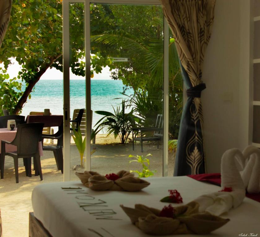 a bedroom with a bed with a view of the ocean at Crown Beach Villas in Dhiffushi