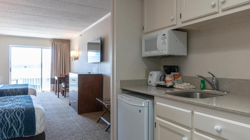 a kitchen with a sink and a room with a bed at Comfort Inn Ocean City Boardwalk in Ocean City