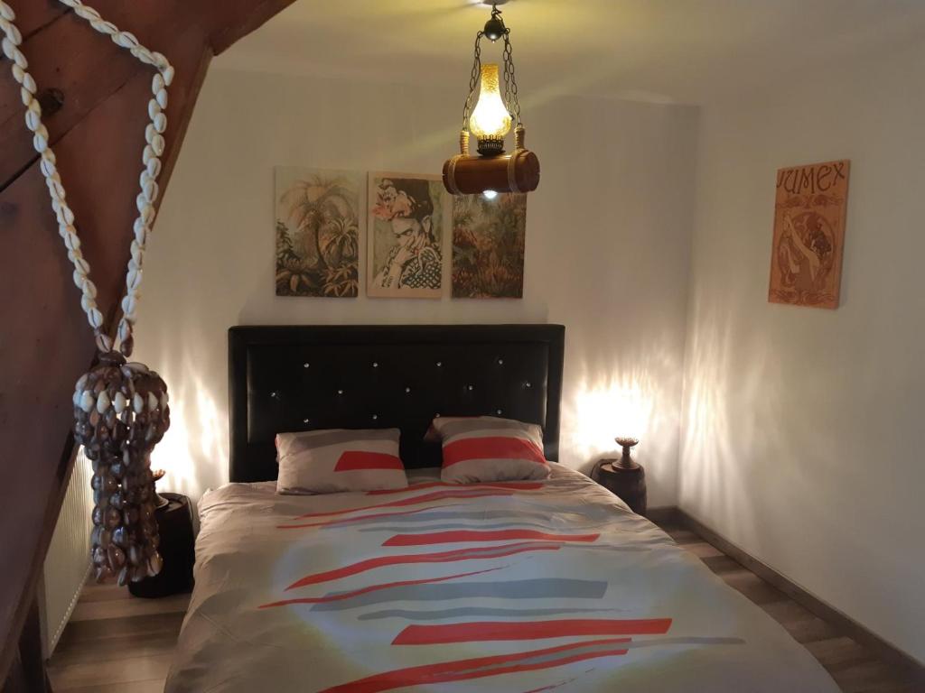 een slaapkamer met een bed in een kamer met een lamp bij Repaire des Corsaires Normands in Le Tréport