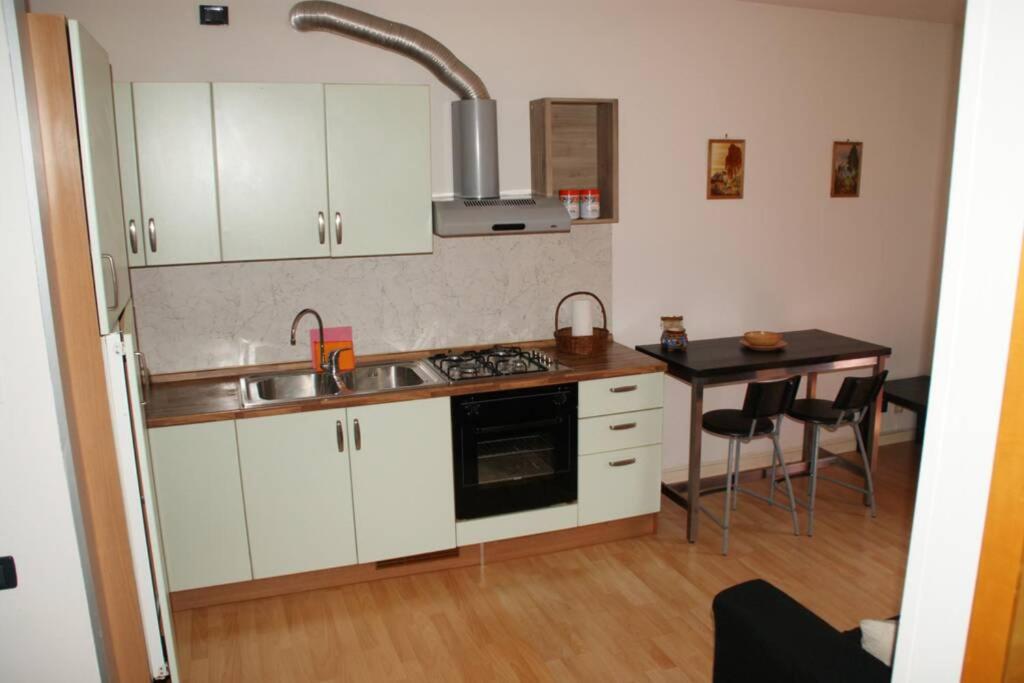 een keuken met witte kasten, een wastafel en een tafel bij Appartamento Casa Paola in Vigonza