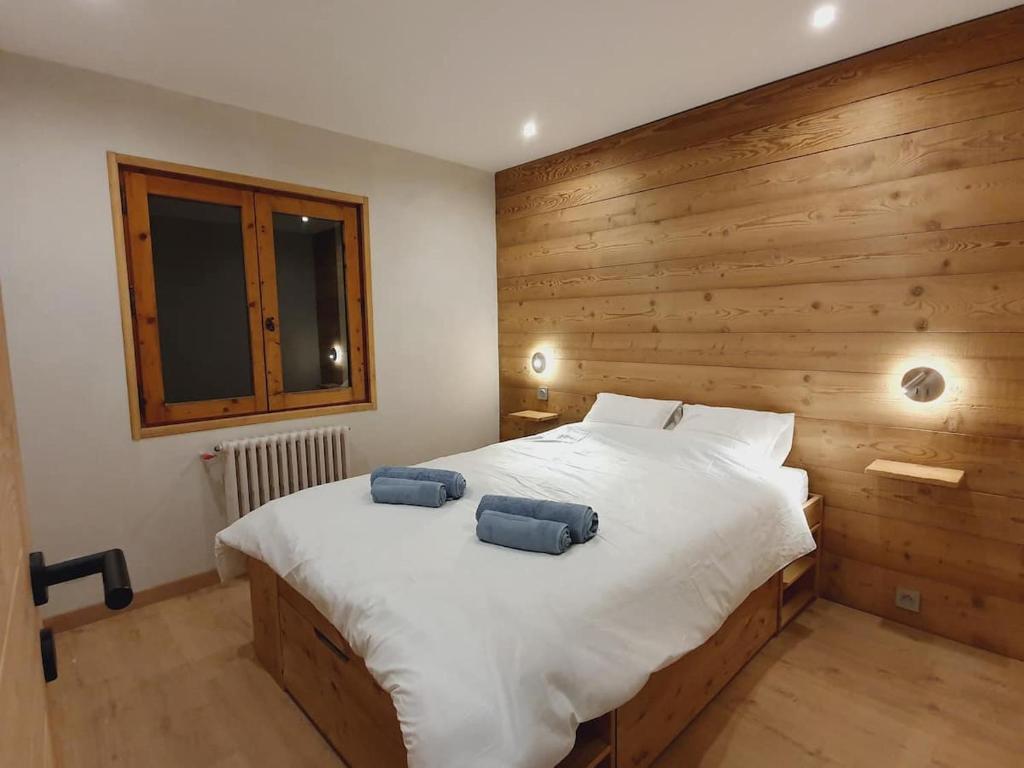um quarto com uma cama com duas almofadas azuis em *** Le Refuge *** Logement standing Megève em Demi-Quartier