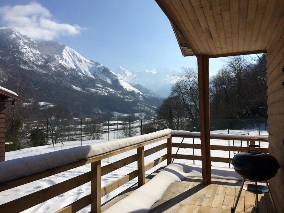 a balcony with a view of a snow covered mountain at Chalet de l'Ours Brun, gîte 3 étoiles in Gère-Belesten