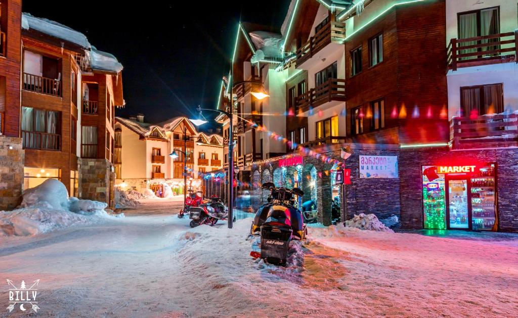 a street covered in snow at night with buildings at GVC New Gudauri in Gudauri