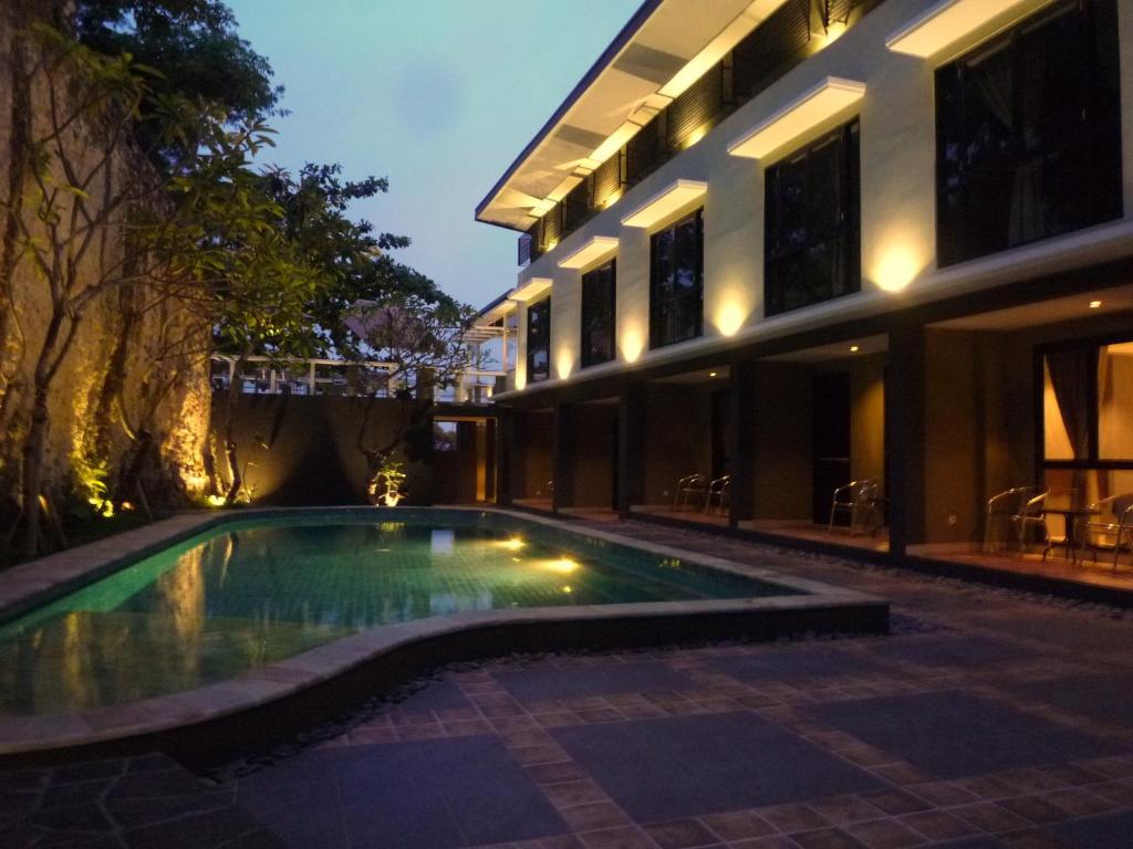 a swimming pool in front of a building at night at White Rock Lodge in Nusa Dua