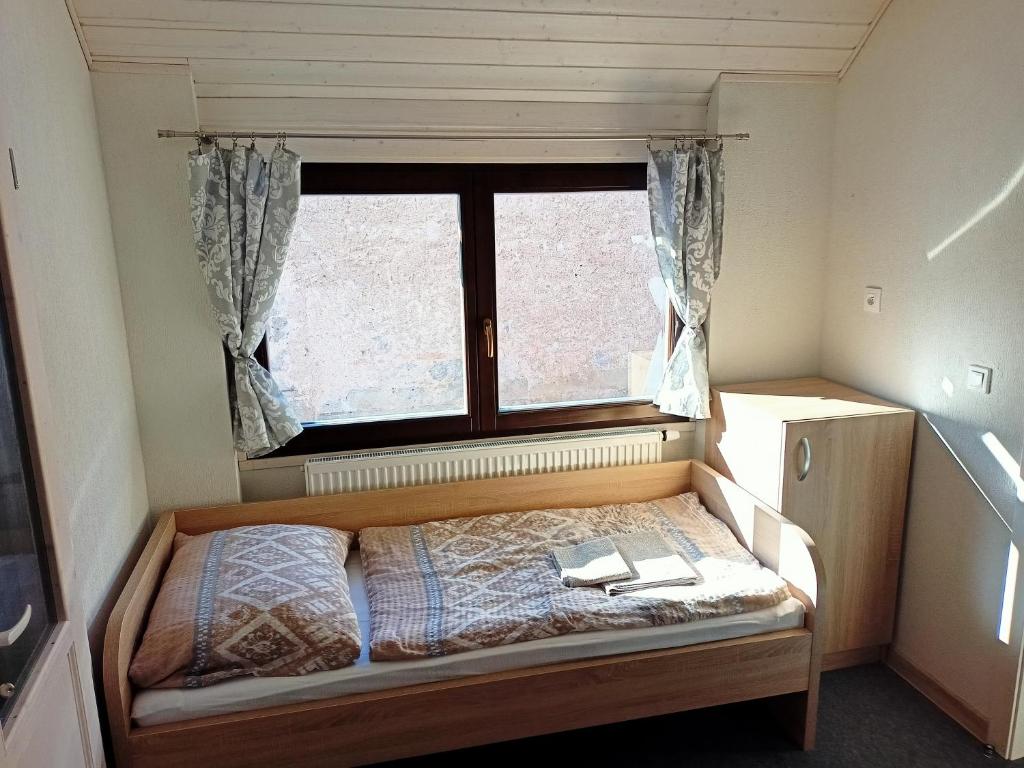 a small bedroom with a bed and a window at Apartment Tomáš Jendrál in Spišský Štvrtok
