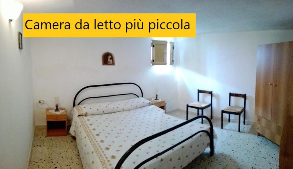 een slaapkamer met een bed en 2 stoelen bij Torre Ovo, Salento, casa in riva allo Jonio in Torre Ovo