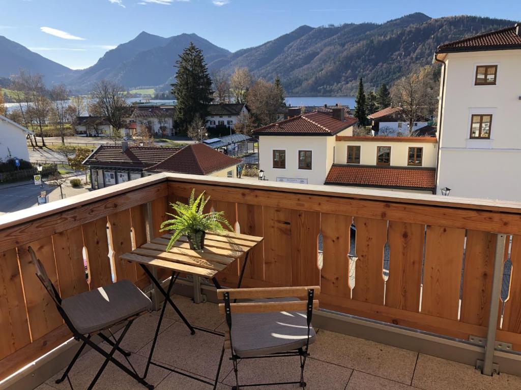 uma varanda com mesa, cadeiras e montanhas em Apartment Berg und See em Schliersee