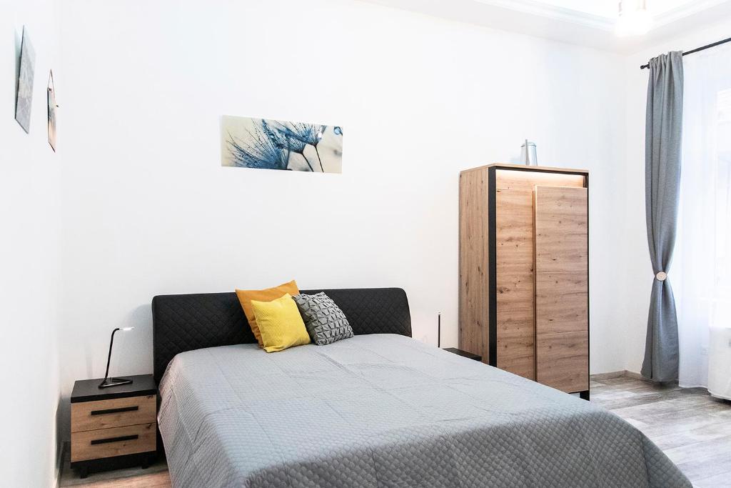 1 dormitorio con 1 cama y armario de madera en Astoria Tiny Apartment en Budapest
