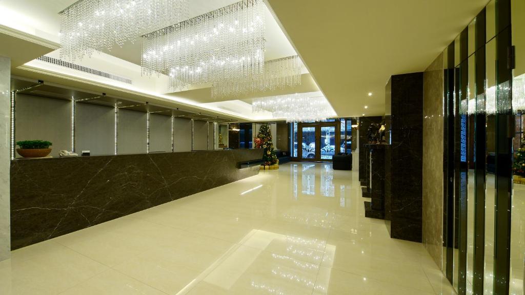 a lobby with a long hallway with a chandelier at Harmonious Hotel in Kaohsiung