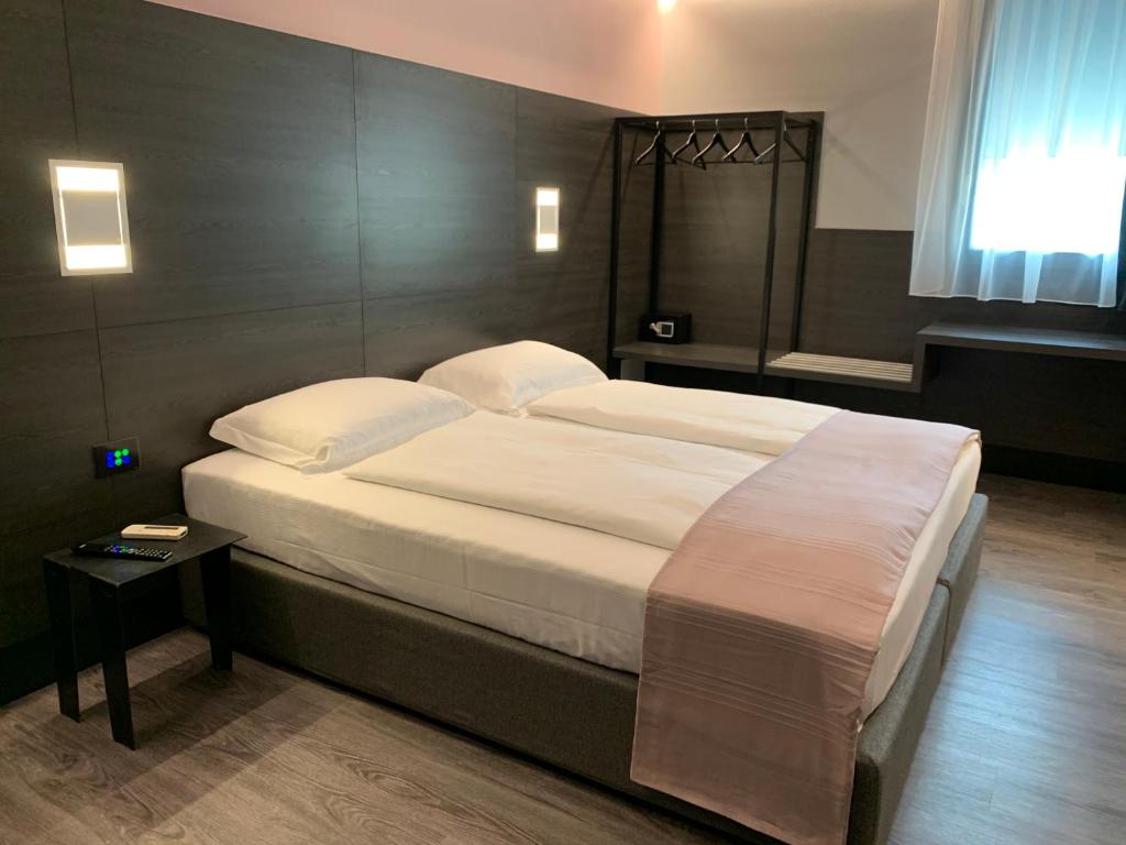 una camera da letto con un grande letto con lenzuola bianche di NAC SUITES a Porpetto