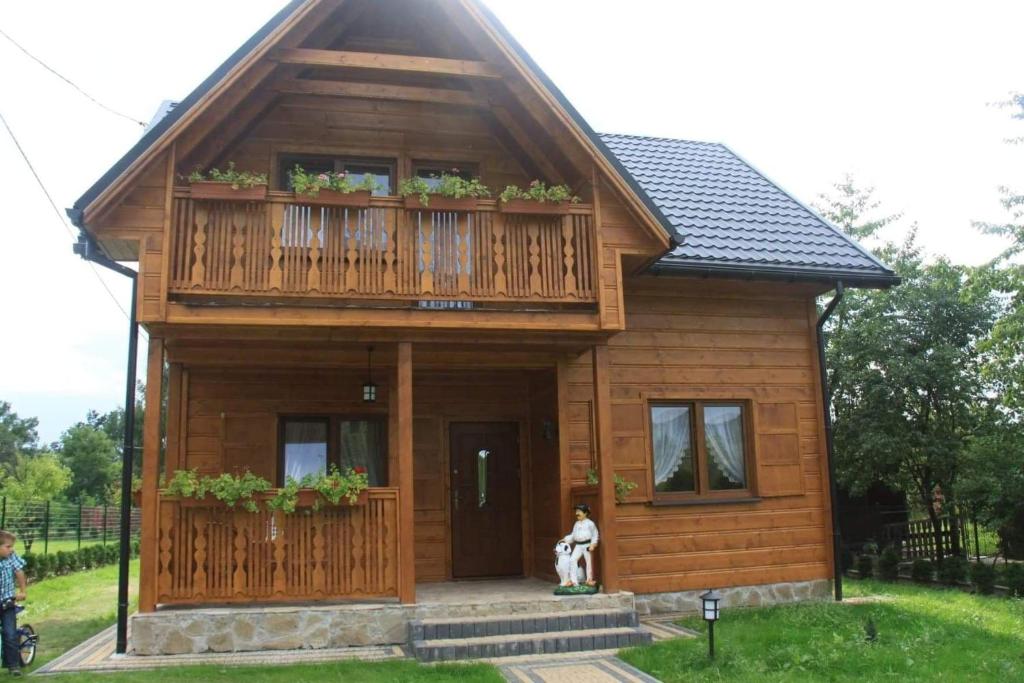 a small wooden house with a balcony on top of it at Chatka z Góralskim Klimatem in Żywiec