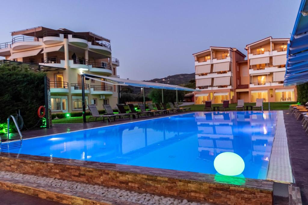 a swimming pool in front of a building at night at Anilio Plaza in Zacharo