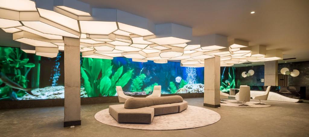 een kamer met een aquarium en een bank ervoor bij Hotel Ilunion San Mamés in Bilbao