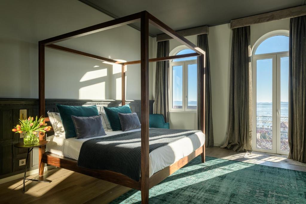 um quarto com uma cama de dossel e vista para o oceano em Pena D'�gua Boutique Hotel & Villas na Covilh�